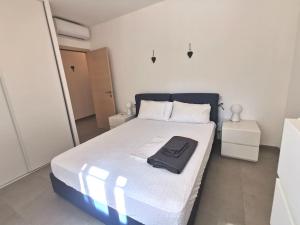 圣弗洛朗Joli appartement face à la mer- St Florent的一间卧室,床上有黑色衬衫
