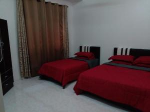 瓜拉丁加奴RZ Homestay的一间卧室配有两张红色床单