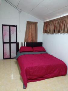 瓜拉丁加奴RZ Homestay的一间在房间内配有红色床的卧室