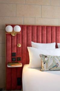 万塞讷Best Western Saint-Louis - Grand Paris - Vincennes的一张带红色床头板的床,上面有白色的枕头和一张桌子