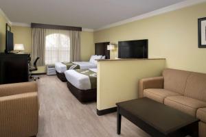 盖洛普Quality Inn & Suites Gallup I-40 Exit 20的酒店客房,设有两张床和一张沙发