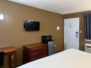 米灵顿Motel 6 Millington TN的卧室配有一张床,墙上配有电视。