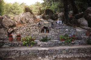 格拉茨莱马Camping TajoRodillo的石墙,花盆和小建筑