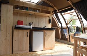 卡兰茨奥赫Panoramatent, in de natuur aan zee的一个带水槽和冰箱的大篷车内的厨房
