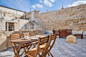 瓦莱塔Vallettastay Old Lodge Apartment 3的天井上的木桌和椅子