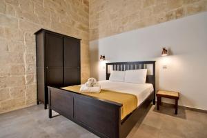 瓦莱塔Vallettastay Old Lodge Apartment 3的一间卧室,卧室内配有一张大床