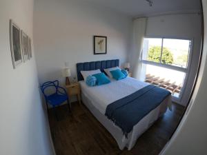 皮拉茹Casa francesa de Piraju的一间卧室配有一张带蓝色枕头的床和一扇窗户。