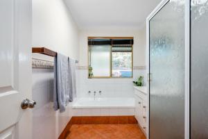 德韦灵阿普Forest Trails House, Dwellingup的白色的浴室设有浴缸和窗户。