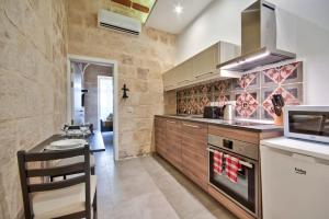 瓦莱塔Vallettastay Old Lodge Apartment 4的一间带柜台和炉灶的厨房 顶部烤箱