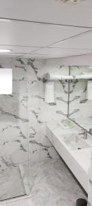 迪拜Fortune Plaza Hotel, Dubai Airport的浴室设有白色大理石墙壁和白色水槽。