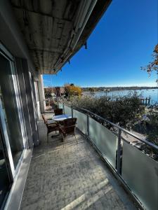 巴多利诺Front Lake Apartment Bardolino的阳台配有桌椅,享有水景。