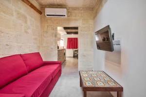 瓦莱塔Vallettastay Old Lodge Apartment 7的客厅配有红色沙发和电视