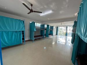 瓦尔卡拉Soul, Varkala - Black Beach的客房配有蓝色窗帘和吊扇。