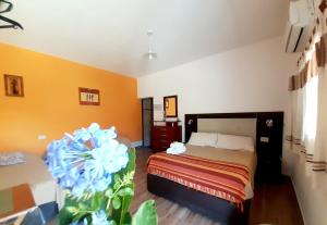 蒂诺加斯塔Hostal Sisabel的一间卧室配有一张床和一朵蓝色的花