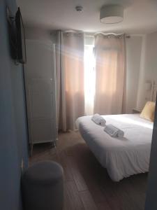 阿尔赫西拉斯Punta Carnero Hostal singular的一间卧室配有一张床、一台电视和一把椅子