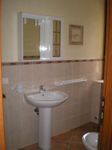 San Chirico Raparo罗莎玛丽亚别墅酒店的一间带水槽、镜子和卫生间的浴室