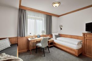 圣安东阿尔贝格格斯力可酒店的酒店的客房 - 带1张床、1张桌子、1张床和1张床