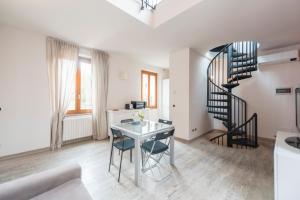 米兰Heart Centre Milan Navigli 3 Levels Apartment的客厅设有螺旋楼梯和桌子