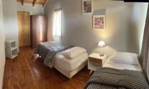 圣卡洛斯-德巴里洛切Hermosa y confortable casita en Bariloche的小房间设有两张床和一盏灯