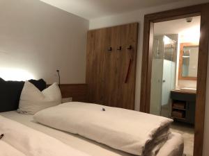 贝旺Gasthof Bergblick的一间带白色床的卧室和一间浴室