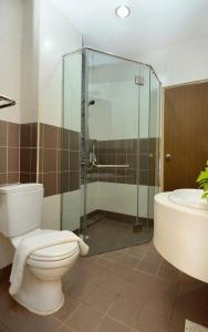 哥打巴鲁哥打巴鲁假日别墅套房酒店的一间带卫生间和玻璃淋浴间的浴室