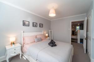 伯恩茅斯A beautiful and stylish 2 bed flat close to beach的卧室配有白色的床和白色床头柜。