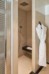 巴黎Maison Albar - Le Pont-Neuf的浴室设有淋浴,墙上有浴袍