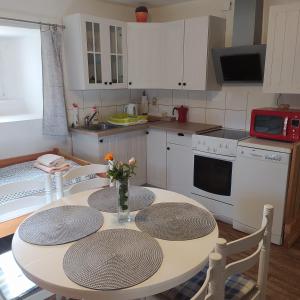 Loučovice德沃勒科纳公寓的一间带一张桌子和两把椅子的厨房和一间带白色橱柜的厨房