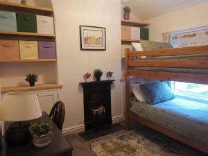 兰贝里斯Prime location for Snowdon, Family and Dog friendly!的一间卧室配有一张双层床和一个壁炉