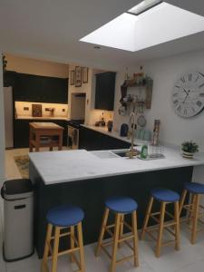 兰贝里斯Prime location for Snowdon, Family and Dog friendly!的厨房配有柜台和3张蓝色吧台凳
