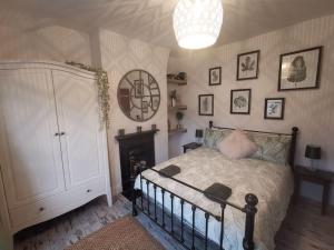 兰贝里斯Prime location for Snowdon, Family and Dog friendly!的一间卧室配有一张床和一个吊灯