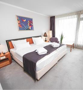 盖尔森基兴PLAZA Hotel Gelsenkirchen的一间卧室配有一张带白色床单的大床