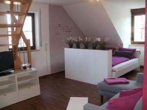 诺尔德海姆Gästehof - Weinbau Säger的客厅配有紫色家具和楼梯