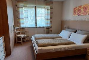 诺尔德海姆Gästehof - Weinbau Säger的一间卧室配有一张带椅子的床和一扇窗户
