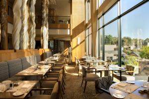 乔治奥巴艾高尔夫和Spa度假村的餐厅设有桌椅和大窗户。