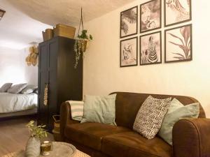 阿尔豪林德拉托里Casita Azahar Andalucia的客厅配有棕色的沙发和墙上的照片