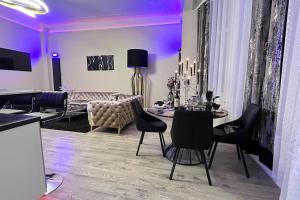 梅斯Appartement de luxe avec Jacuzzi au centre de Metz的客厅配有紫色照明和桌椅