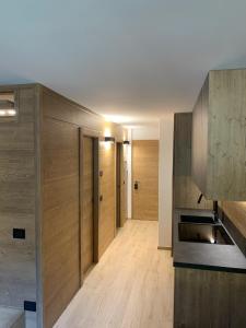 摩德纳迪-坎皮格里奥Des Alpes C Flat 11的一间带木墙的厨房和一个带木地板的走廊
