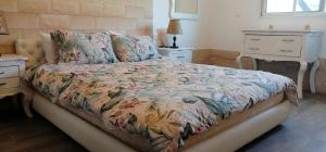 本苏莱曼Ferme Sacrée Nature的一间卧室配有一张带花卉棉被的床