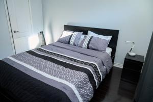 米尔顿Peace Alcove的一间卧室配有一张带黑色床头板和枕头的床。