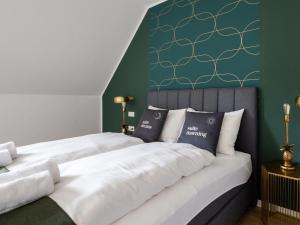 克拉根福limehome Klagenfurt Goessgasse的一间卧室设有两张床和绿色的墙壁