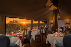 Aitong马哈里姆苏里山林小屋的用餐室配有桌椅,享有日落美景