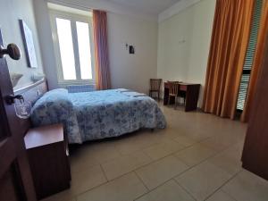 托雷安农齐亚塔Villa Tiberiade的一间卧室配有一张床、一张桌子和一个窗户。