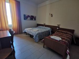 托雷安农齐亚塔Villa Tiberiade的酒店客房设有两张床和一张桌子。