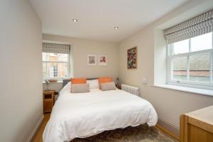 韦尔斯Stylish two bed flat, city centre, free parking的卧室配有白色的床和2扇窗户。