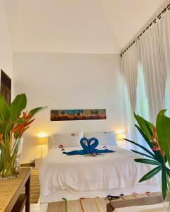 象岛Maddekehaoo Eco Mansion的一间卧室配有一张白色床,上面有蓝色的花朵