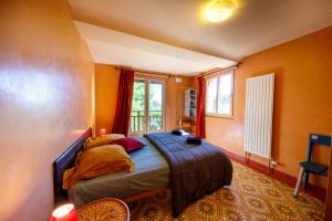吉洛梅Eco-hôtel et Yourtes du Mercantour的一间设有床铺的卧室,位于一个拥有橙色墙壁的房间