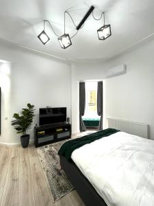 布加勒斯特Green Spot - Premium Studio - Sanador Victoriei的一间白色卧室,配有床和电视