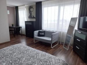 陶格夫匹尔斯Vienibas apartment的一间卧室配有椅子、电视和桌子