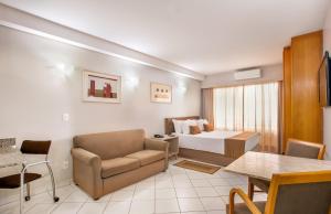 圣保罗美国阁楼广场酒店的酒店客房配有床、沙发和桌子。